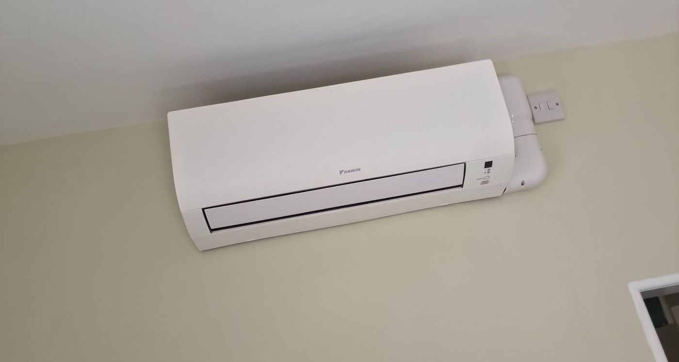 Finished Daikin wall-mounted air conditioning unit installed in a decorated room